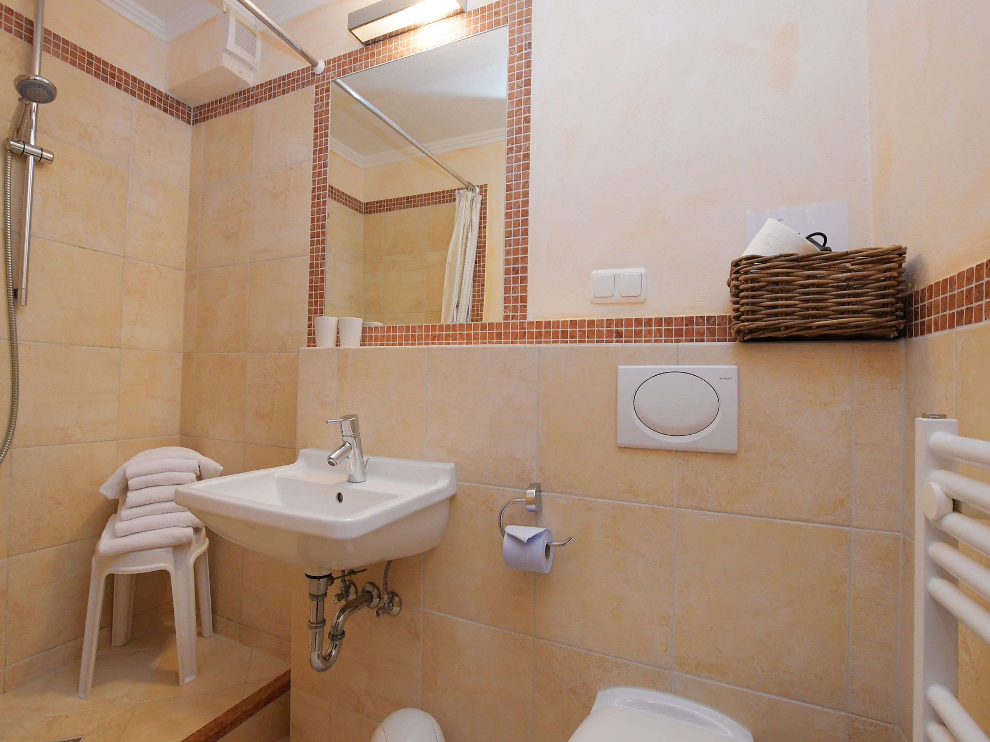 A bathroom with a sink, toilet, and shower.
