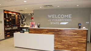 Una mesa de recepción con un letrero que dice "Welcome to the Volunteer State", el logotipo de Hilton y una pared con diseño de madera.
