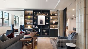 Un salon moderne avec un canapé, une table basse et une bibliothèque remplie de livres et d’objets décoratifs.
