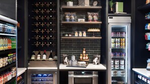Une petite cuisine équipée comprenant un réfrigérateur à vin, un mini-réfrigérateur et divers produits alimentaires.