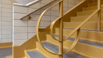Una escalera con barandilla circular y pasamanos de metal.