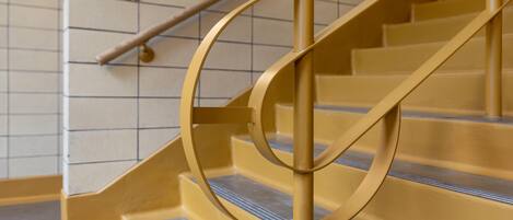 A staircase with a circular handrail and a metal railing.