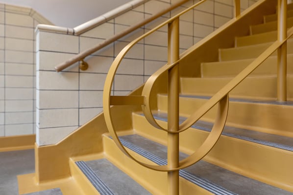 Una escalera con barandilla circular y pasamanos de metal.