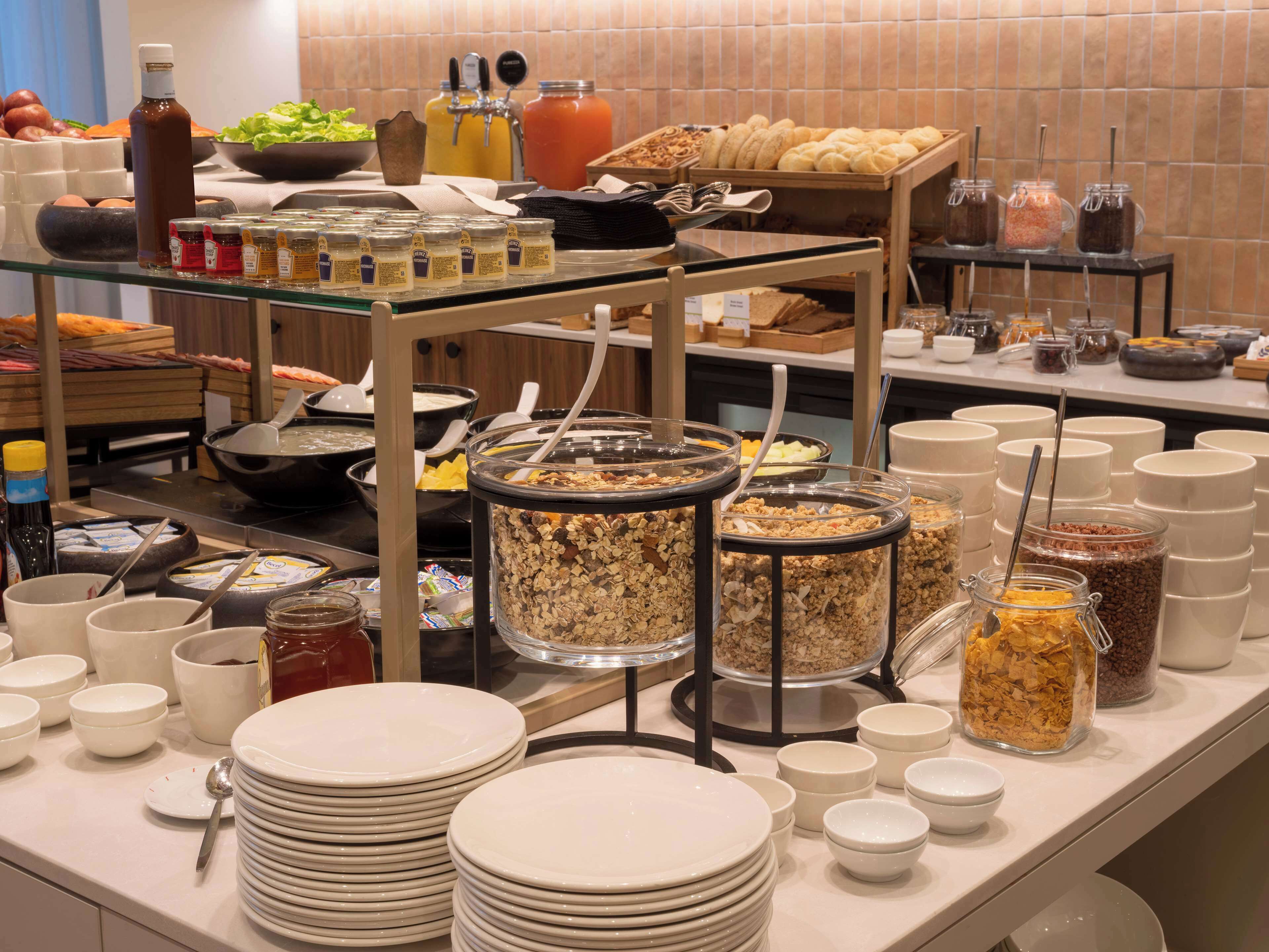 Een buffetopstelling met diverse gerechten, sauzen en bestek.