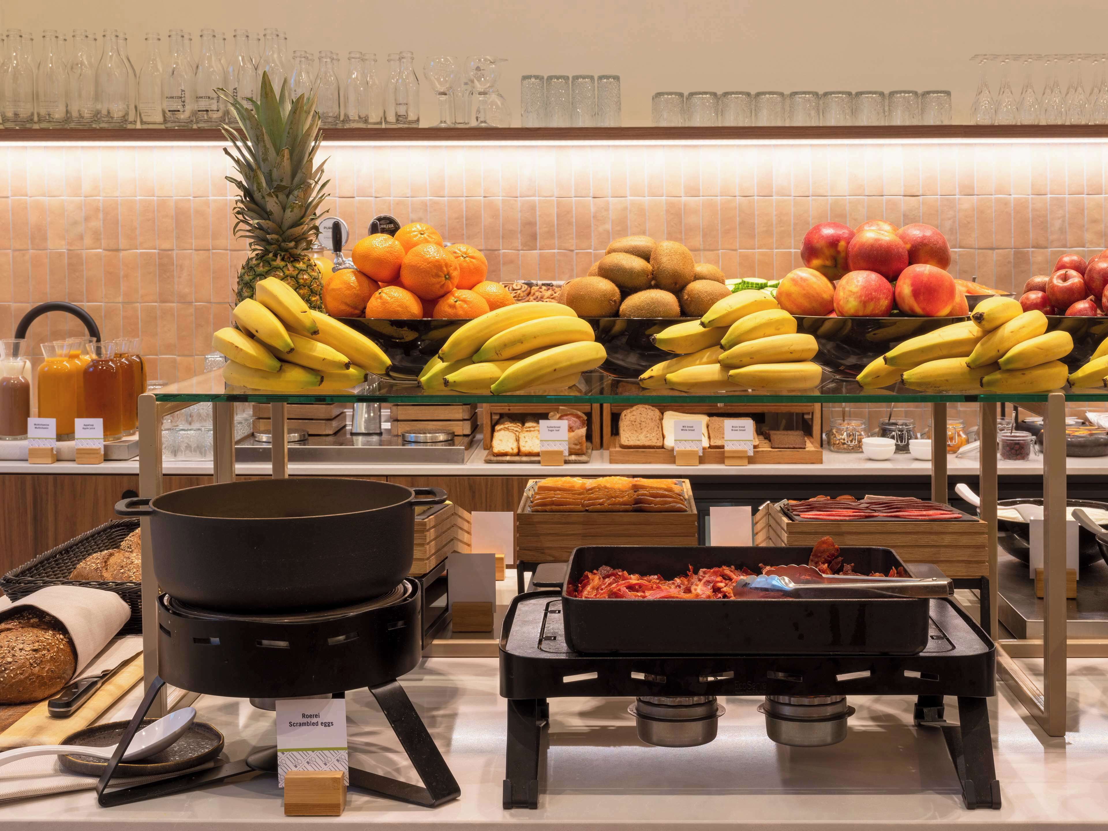 Un buffet proposant une variété de fruits, de pain et d’œufs brouillés.