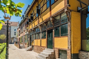 A traditional building with a yellow facade, wooden beams, and large windows.