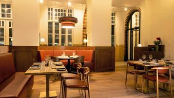 A restaurant with wooden flooring, tables set for dining, and a warm, inviting atmosphere.