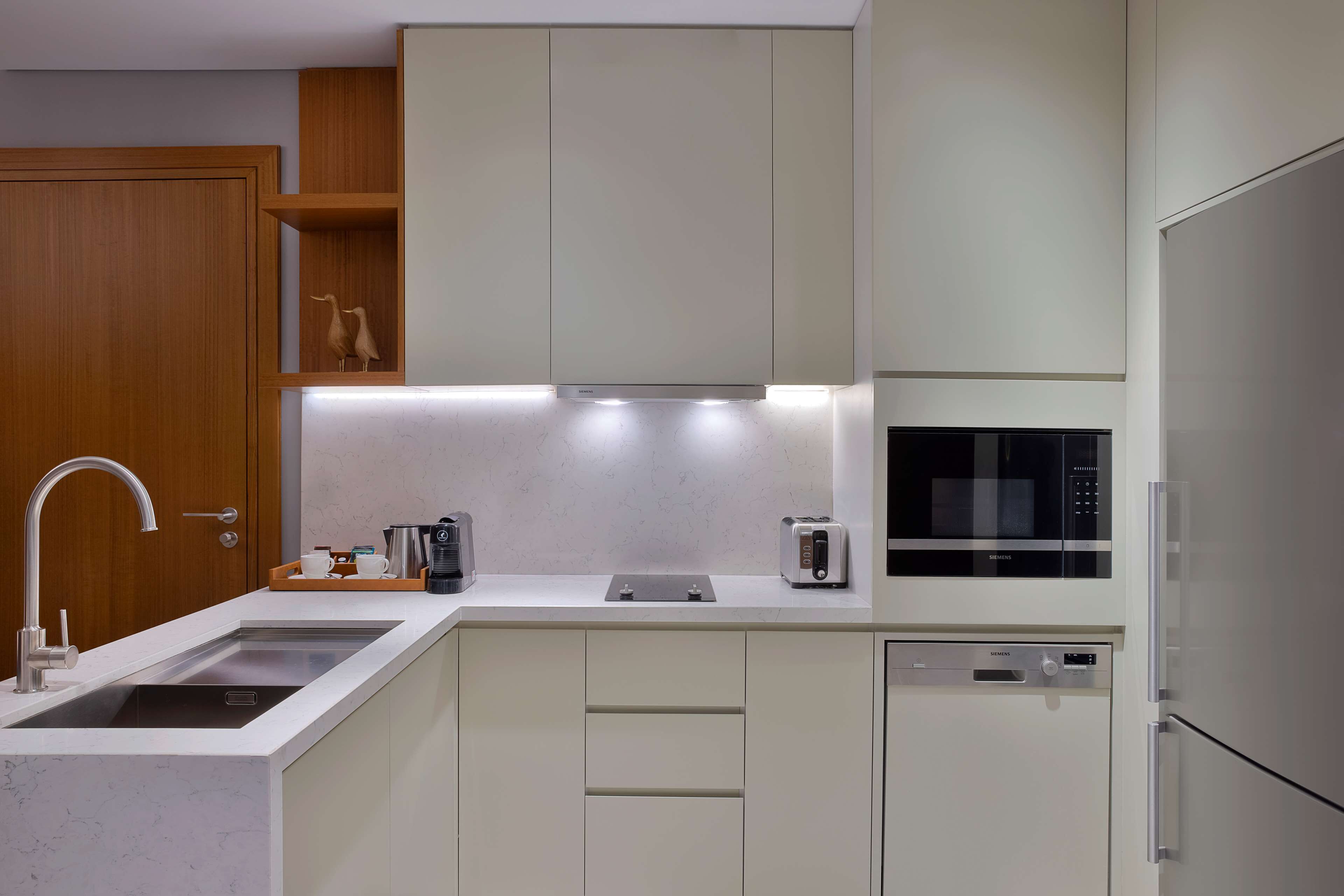 A modern kitchen with a built-in dishwasher, a microwave, and a toaster.