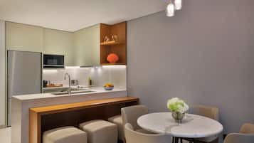 A modern kitchen with a central island, a dining area with a round table, and a built-in microwave.
