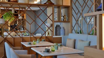 A modern interior with seating areas, tables, and decorative items.