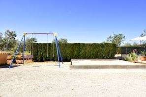 Un parque infantil con columpios y un arenero.