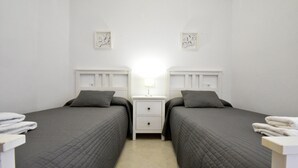 Une chambre double avec deux lits, une table de chevet avec une lampe et une œuvre d’art accrochée au mur.