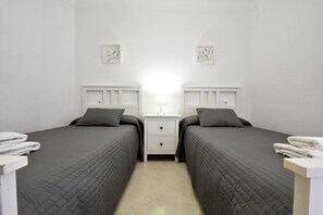 Une chambre double avec deux lits, une table de chevet avec une lampe et une œuvre d’art accrochée au mur.