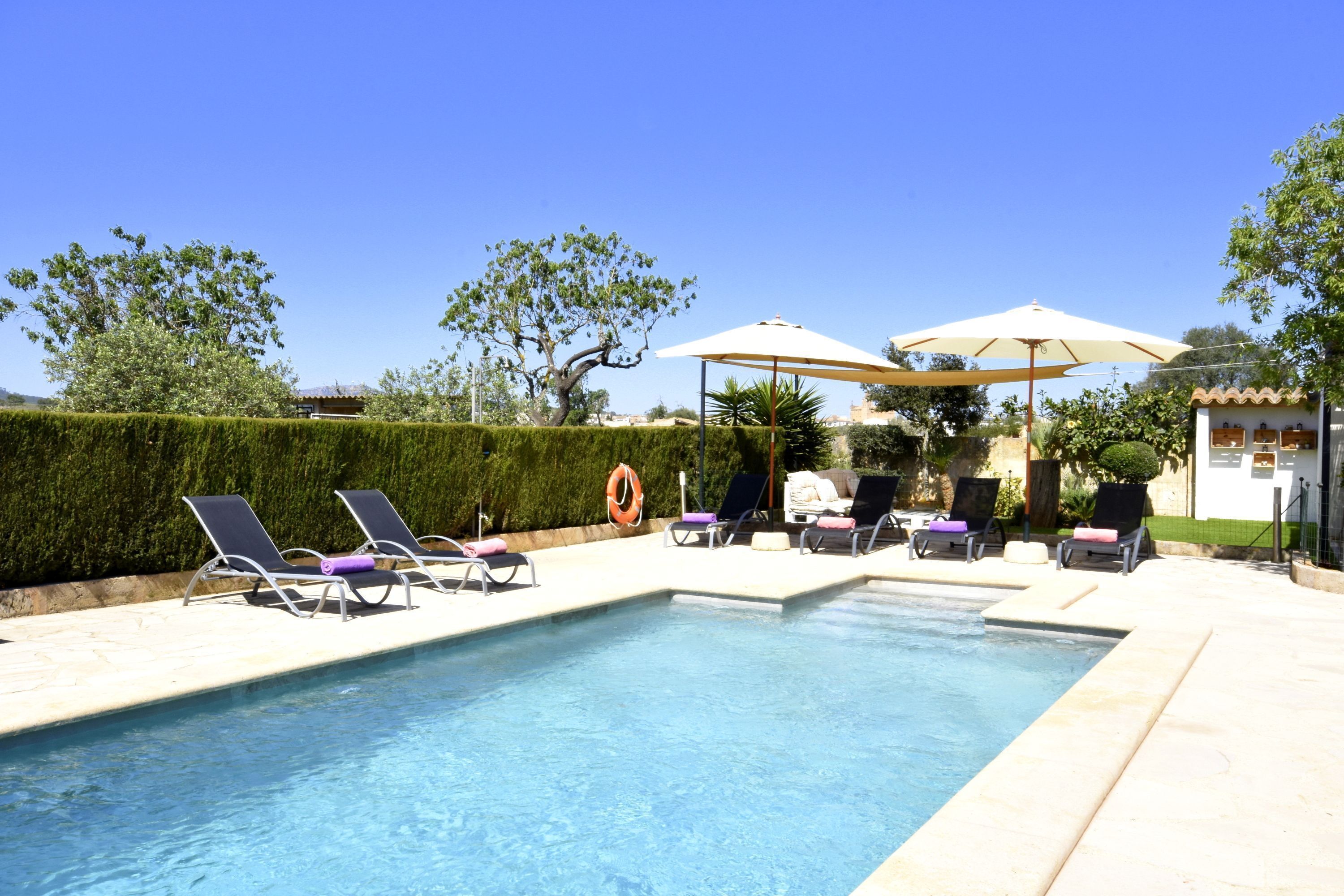 A swimming pool with lounge chairs and umbrellas.