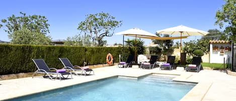 A swimming pool with lounge chairs and umbrellas.