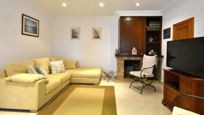 A living room with a sofa, a television, a fireplace, and a bookshelf. - 44262 Finca Els Xiprers (Porreres)