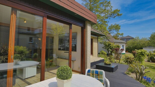 A patio area with a round table and chairs, a potted plant, and a glass door leading to a room. - N 40 GH 4-room Terr. (BC.n5) - Stranddomicil Steiner - Guesthouses (Büsum)