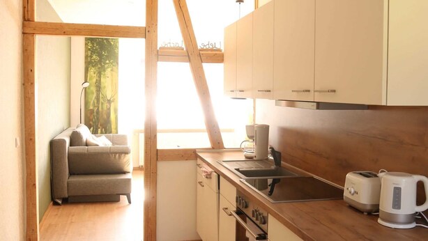 Eine moderne Küche mit Holzausstattung, einem eingebauten Ofen und einer Holz Arbeitsplatte.