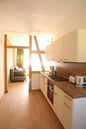 Une cuisine moderne avec des meubles de rangement en bois, un four encastré et un plan de travail en bois.