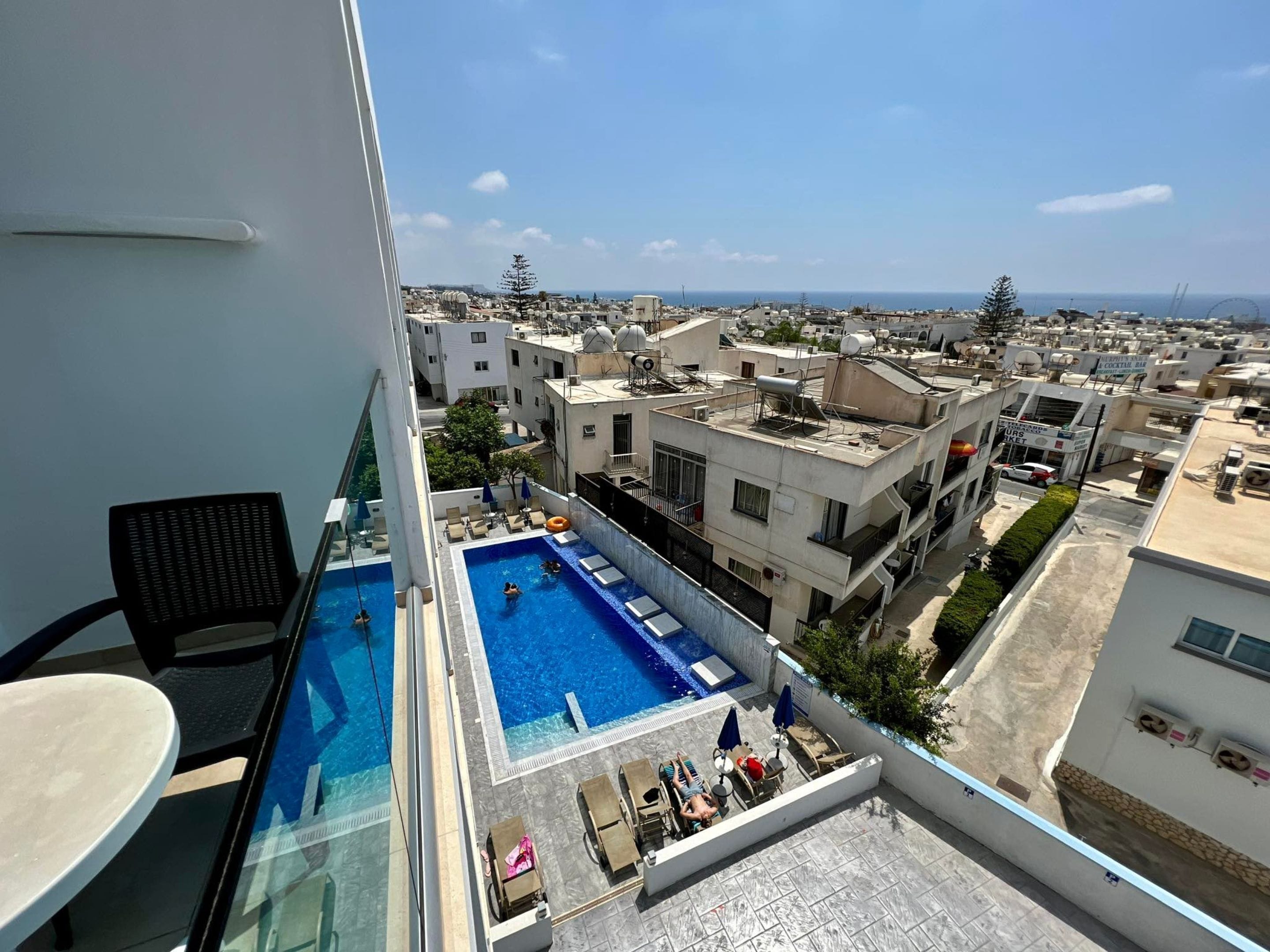 A rooftop pool with lounge chairs and a view of the cityscape.