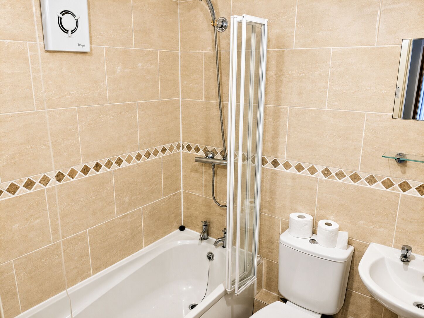 Ein Badezimmer mit Badewanne, Toilette und Waschbecken, alles in Weiß.