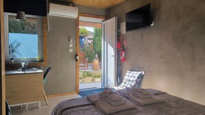 A bedroom with a bed, a desk, a chair, a TV, and a sliding glass door to a balcony. - Ruby Charm Houses 11 116353/AL (Porto)
