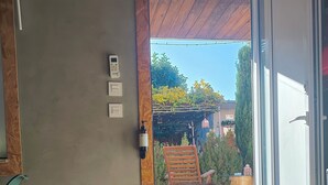 A room with a bed, an air conditioning unit, a wall-mounted control panel, and a view of the outdoors through a glass door. - Ruby Charm Houses 11 116353/AL (Porto)