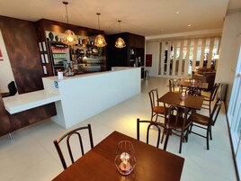 Un área de bar moderna con barra, asientos y vista al salón.