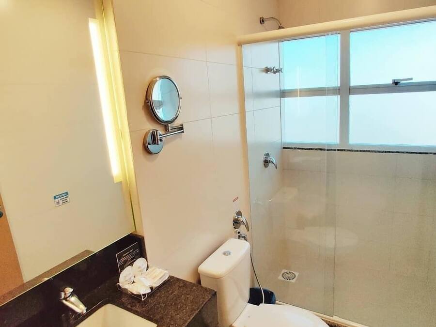 A bathroom with a sink, toilet, and a glass-enclosed shower.