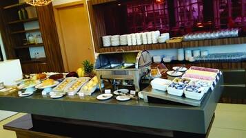 A buffet setup with various food items and utensils.