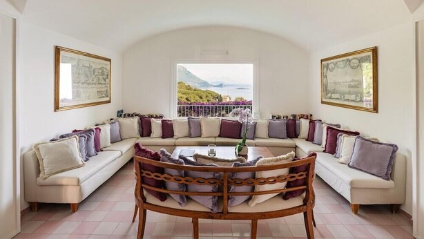A semi-circular living room with a sofa set, a coffee table, and a view of the outdoors. - Santavenere Hotel (Maratea)