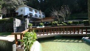 A hotel with a pool, a wooden bridge, and a staircase leading to the upper floors. - Hotel El Paraiso (Mineral del Chico)