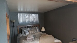 A bedroom with a bed, pillows, a window, a lamp, and a bedside table. - Studio getaway steps away from Big Sky Resort (Big Sky)