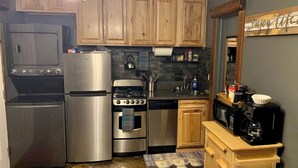 A compact kitchen with a refrigerator, stove, oven, microwave, and a coffee maker on a wooden counter. - Studio getaway steps away from Big Sky Resort (Big Sky)