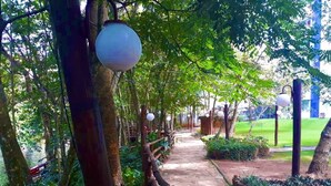 Un sendero bordeado de árboles y faroles colgantes que lleva a un edificio con techo de tejas.