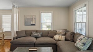 Una sala de estar con un sofá modular, una mesa de centro y un cuadro en la pared.