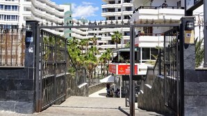 A gated entrance to a residential complex with multiple balconies and a clear sky. - Lighthouse Friendly Holiday Home (Playa del Inglés)