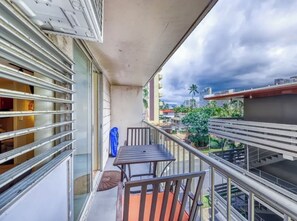 Enjoy the view from this balcony with a table and two chairs.