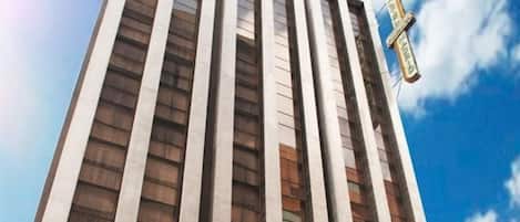 Un alto edificio di un hotel con un cartello che riporta "Hotel Plaza Madrid" e un cartello ben visibile con la scritta "Garage".