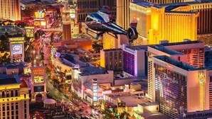 A cityscape with a prominent casino building, a helipad, and a busy street. - Las Vegas Timeshare at Wyndham Desert Blue (Las Vegas)