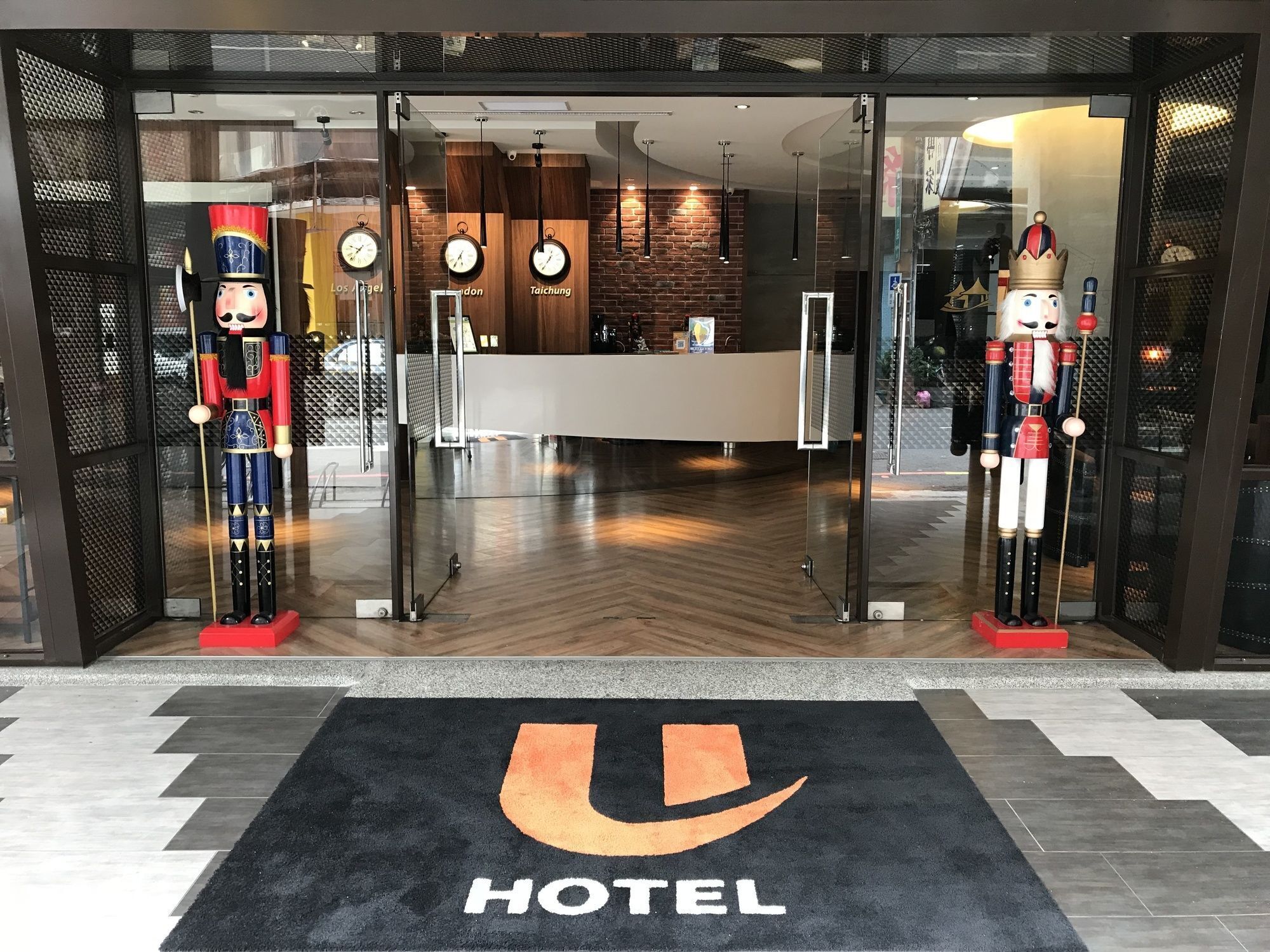 A hotel entrance with a reception desk, clocks, and nutcracker statues.