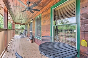 Eine Holzterrasse mit Deckenventilator, Tisch und Stühlen.
