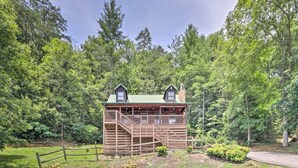 Eine Holzhütte mit Balkon und einer Treppe, die zum oberen Stockwerk führt.
