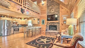 Ein großzügiges Holzblockhaus-Interieur mit Küche, Essbereich und Kamin.