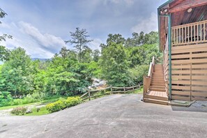 Eine Beton-Terrasse mit einer Holztreppe, die zu einem Gebäude mit einem Balkon führt.