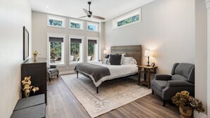 A bedroom with a bed, a desk, a chair, a floor lamp, and a window with a view of trees. - Air-Conditioning, Privacy, Family Retreat! (Durango)