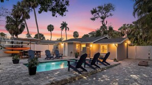 A backyard with a swimming pool, lounge chairs, and a patio area. - Canal-Front Oasis in Terra Ceia: Pool, Patio, Dock (Terra Ceia)