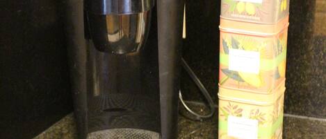 A coffee maker and stacked containers on a kitchen counter.