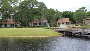 Une propriété au bord du lac comprenant plusieurs maisons, un quai et une zone herbeuse.