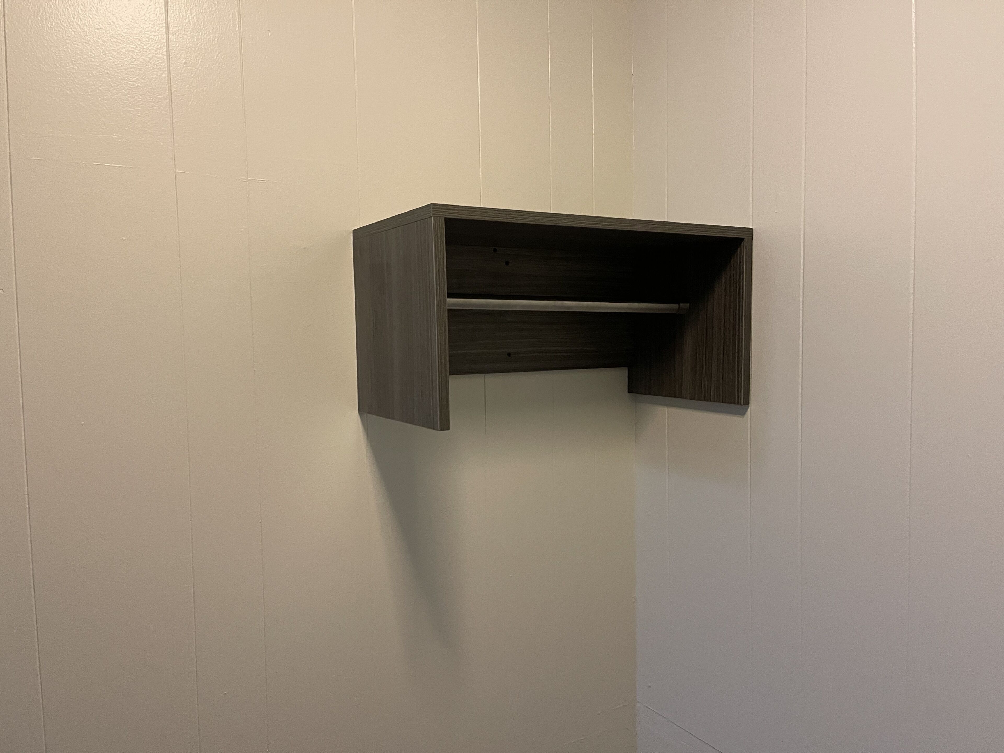 A dark wood shelf mounted on a light-colored wall.